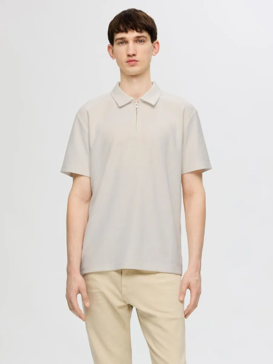 pliss_och_halvlngt_blixtl_0.webp SELECTED PLISSÉ OCH HALVLÅNGT BLIXTLÅS PIKÉTRÖJA Beige Fashion