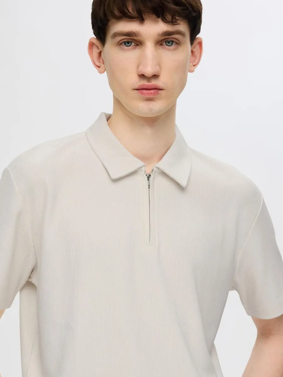 pliss_och_halvlngt_blixtl_2.webp SELECTED PLISSÉ OCH HALVLÅNGT BLIXTLÅS PIKÉTRÖJA Beige Fashion