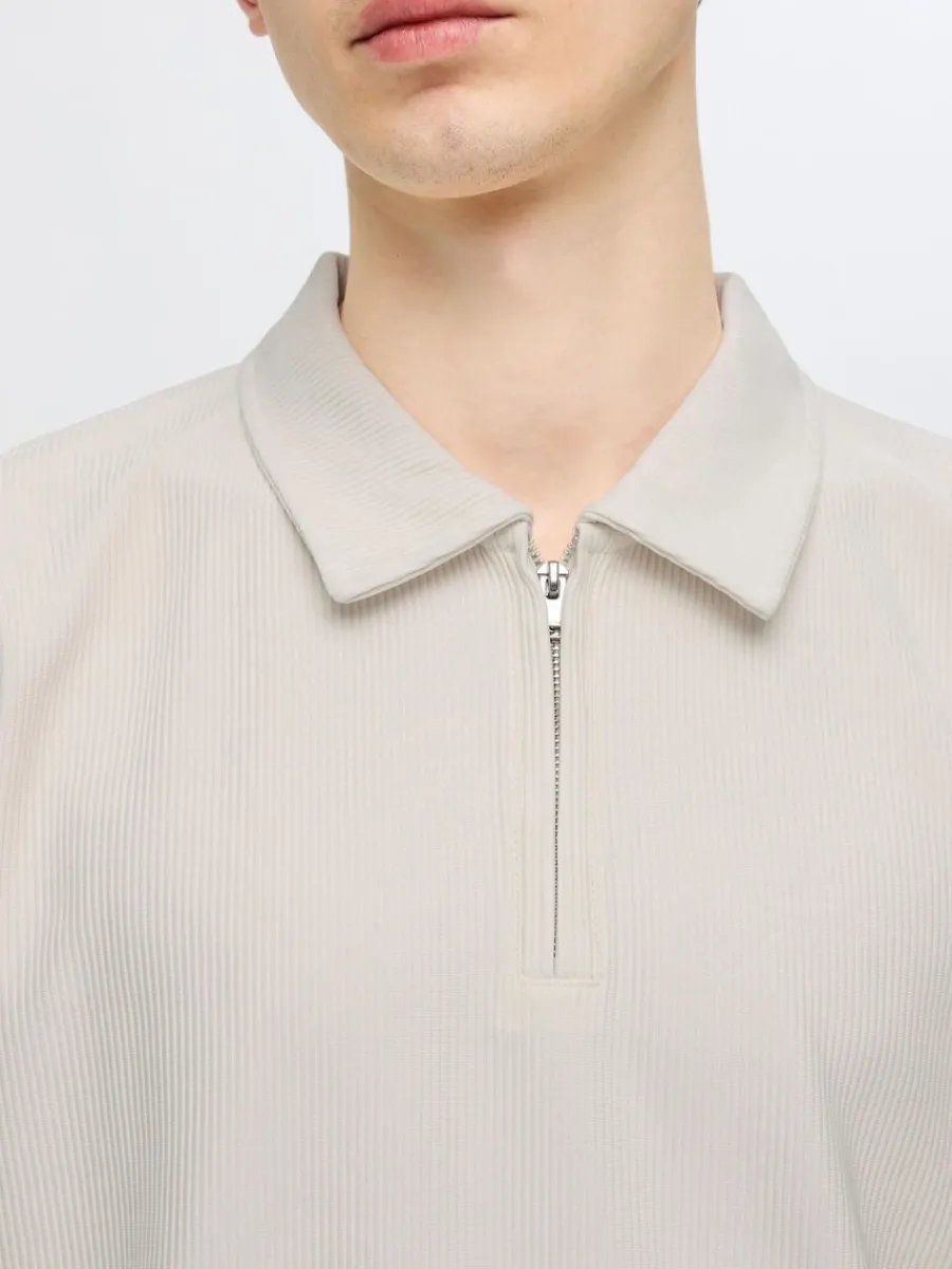 pliss_och_halvlngt_blixtl_4.webp SELECTED PLISSÉ OCH HALVLÅNGT BLIXTLÅS PIKÉTRÖJA Beige Fashion