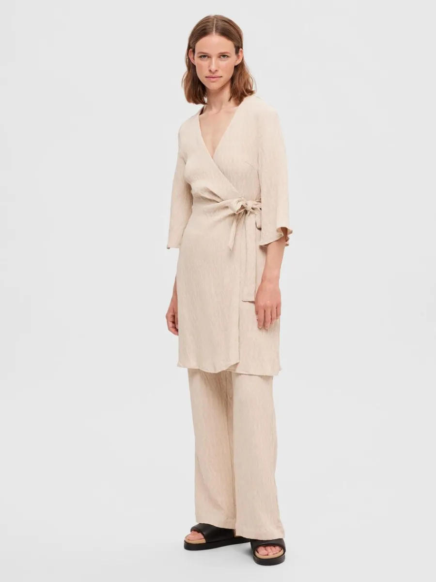 pliss_omlottklnning_1.webp SELECTED PLISSÉ OMLOTTKLÄNNING Beige New